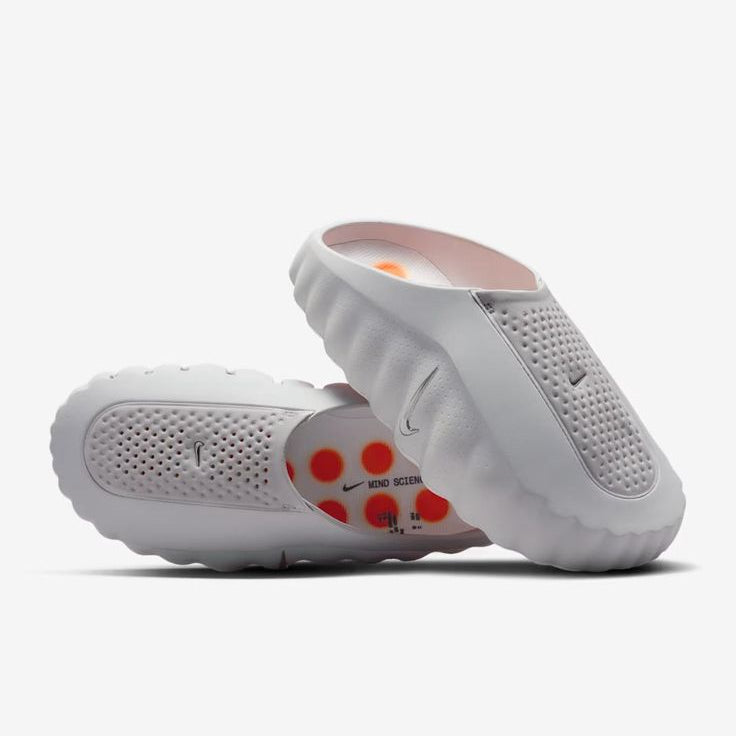 White Nike slide sandals with red accents on a white background